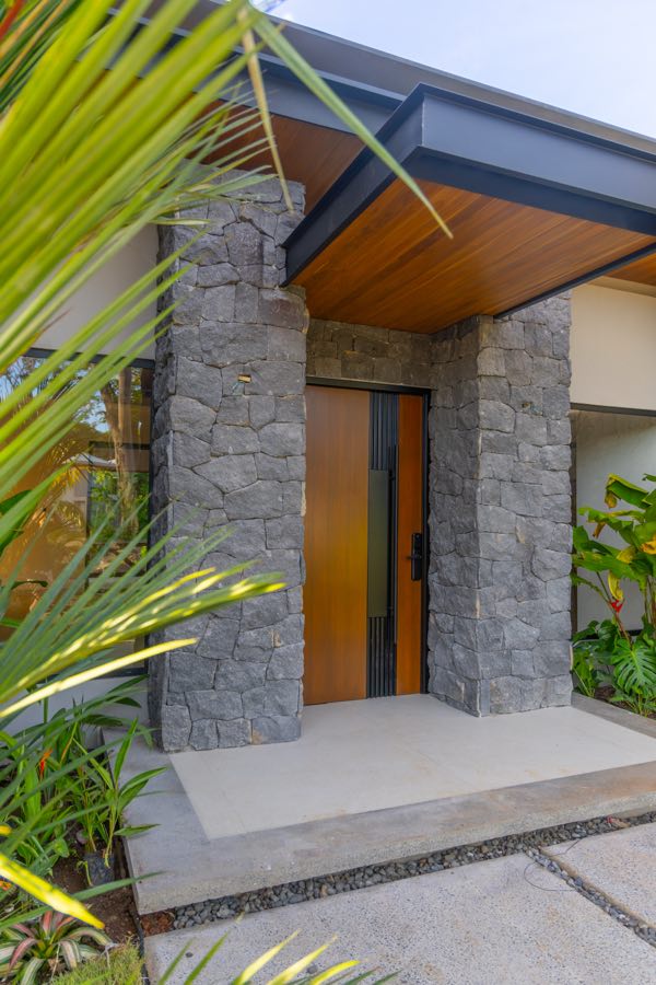 Teak at the entry, volcanic stone at the shoulder