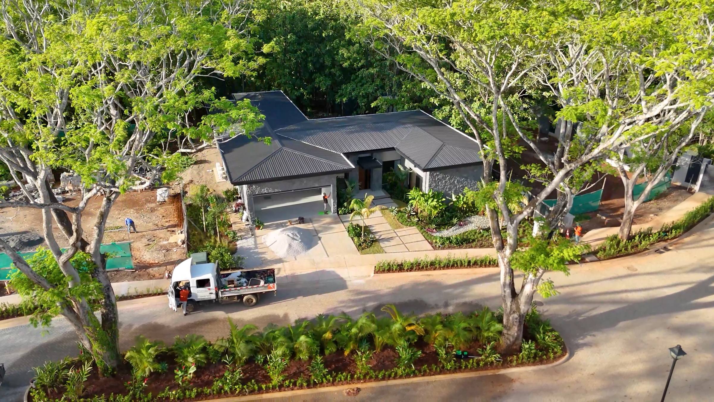 A finished Black Coast residence at Playa Negra from the air &mdash; roof, entry court and planting, with the road curving past